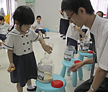 小朋友用回收的奶瓶每天請家長飯前裝一把米，不但可以日食八分飽，另外兩分的米還可以用來幫助別人。【攝影者：李沁倫】