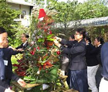 庭園裡用竹子和葉子製作成的聖誕樹。學員們歡喜的為聖誕樹掛滿裝飾品。【攝影者：黃慈諭】