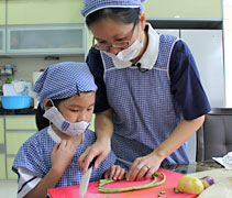 慈濟志工李偉瑩（右）慷慨地借出住家，作為幼兒園拍攝蔬果護照食譜的場地。左為幼兒園小朋友沈婷鈺。【攝影者：胡慧芬】
