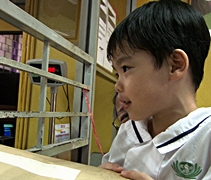 慈濟幼兒園的小朋友以有限的馬來語與郵政局工作人員交流，學習郵寄包裹。【攝影者：莊鞳勛】