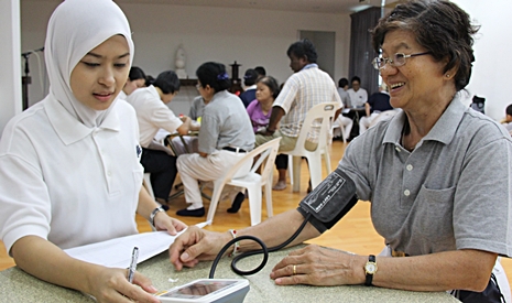 北海洗腎中心的護士希娣 ( Siti Adariyah ) （左）為慈濟志工測量血壓。【攝影者：胡慧芬】