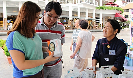 慈濟志工葉明珠（慈如）（右一）向民眾介紹香積飯的簡易煮法。【攝影者：胡慧芬】