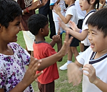 慈濟幼兒園的王禹哲（右）和孤兒院的新朋友面對面、拍拍手，彼此打成一片，就像好朋友一樣【攝影者：胡慧芬】
