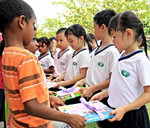 慈濟幼兒園的孩子們恭敬地為孤兒院的新朋友送上一疊疊募集到的書本。【攝影者：胡慧芬】
