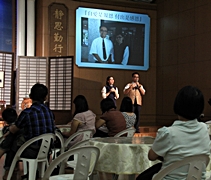同仁李雪瑩（懿瑩）（左）在台上分享行孝心得，身旁還有她的哥哥李健群（誠群）陪伴在旁。【攝影者：胡慧芬】