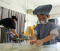 四歲班的孩子負責較簡單的任務，把飯放在飯盒裡。【攝影者：莊鞳勛】