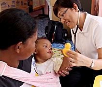 林彩萍醫師（右一）用可愛的玩具哄小孩子，以便能順利幫他進行身體檢查。【攝影者：胡慧芬】
