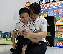 空檔時間，倪芳婷（右）替小朋友細心地檢查身體，是否有感冒發燒。【攝影者：莊鞳勛】