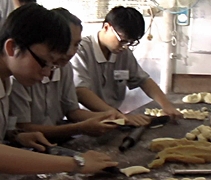 慈大生幫忙腎友沈文興烘制餅干，體驗馬來西亞傳統的手工藝。【攝影者：王懿筠】