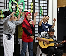 德莉瑪的先生彈奏吉他，女兒西蒂諾阿娣疤則唱誦華語版《一家人》，志工們則手語呈現。【攝影者：何詠宸】