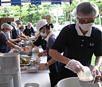 7時30分，慈濟志工們自動就位，一起盛飯舀菜，打包便當。【攝影者：黃誠恕】