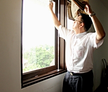 握著報紙，財務主任黃書福使勁地將窗口擦拭干淨。【攝影者：胡慧芬】