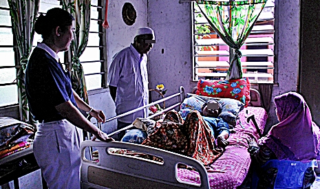 慈濟志工與腎友前來探訪腎友沙布丁（白衣者）及癱瘓數年的妻子柔碧雅。【攝影者：顏如艷】