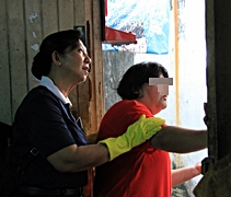 照顧戶林亞月（右一）在志工陪伴下，看著木工修繕自己家裡的屋頂。【攝影者：莊鞳勛】