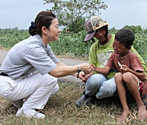 慈濟志工王麗萍以流利的泰語，為達娜姆和她的小兒子獻上祝福與膚慰。【攝影者：顏如艷】