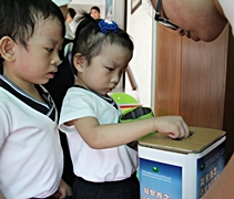 小朋友把撲滿裡的善款投入愛心箱，送愛到菲律賓。【攝影者：魏嘉妍】