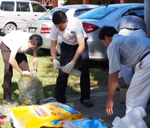 人醫會醫師黃偉雄（左）和劉祐財（中）以身作則，帶頭跟著慈濟志工一起彎腰做環保，將回收物作分類。【攝影者：李志旺】