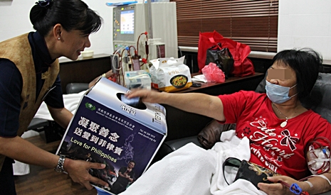 慈濟志工鄧素麗（慈憫）（左）捧著愛心箱向腎友籌募善款。【攝影者：胡慧芬】