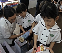 高淵慈濟幼兒園老師帶動小朋友把平日投錢的愛心竹筒，捐給菲律賓的受災鄉親。【攝影者：莊鞳勛】