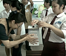 掏出零錢，學生紛紛將善款投入愛心箱裡，將愛送到菲律賓。【攝影者：楊蘊美（慈操）】