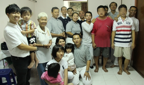 慈濟志工和回收站的社區志工們，齊聚兩兄弟的家，為哥哥徐世明（前排站立者右一）慶祝36歲生日，紅衣者為弟弟錢本全。【攝影者：顏如艷】