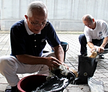 同仁忙著清洗雨鞋，為事前准備出一份力。左一起為劉秋安（濟心）、羅漢賜（濟熹）。【攝影者：胡慧芬】