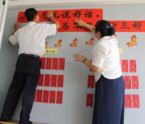 許證勝（濟韡）師兄與幼兒園園長譚莉璉（慈遵）細心的把春聯貼上。【攝影者：魏嘉妍】