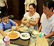 在學習用餐禮儀後，孩子們馬上練習如何為父母端上食物。【攝影者：胡慧芬】