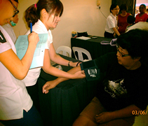 兩位藥劑師梁欣怡（左）和顏秋瑩（中），正在為居民測量血壓。【攝影者：陳思穎】