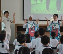 洗腎中心的護理人員李曉茹（左一），蒂雅娜（Siti Nur Diyana bt Hassan）（中）及張旖潔（右）帶領小朋友們「心富大幸福」的手語表演。【攝影者：許證勝】