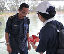 慈濟志工向岸警衛隊隊員解釋，所有的小點心都是適合馬來人同胞享用。【攝影者：莊鞳勛】