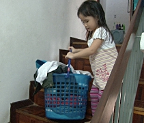 今年六歲的程穎柔，卻有著無比的力氣，學會幫忙媽媽拿衣服放進洗衣機洗。【攝影者：胡慧芬】