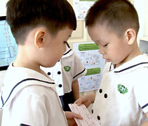 在學校裡，楊浩宇興奮地拿著月捐收據，交給他的月捐會員。【攝影者：胡慧芬】
