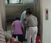 慈濟志工扶着行動不方便的腎友走入電梯內，到全新二樓洗腎室洗腎。【攝影者：陳瑞文】