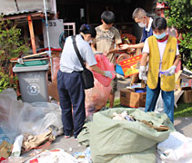 志工帶動照顧戶兒子林友華做清理工作。【攝影者：葉俍輝（濟岸）】
