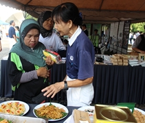 慈濟志工馬耀甄（慈甄）向民眾一一介紹靜思食品所製作出的素食料理。【攝影者：魏嘉妍】