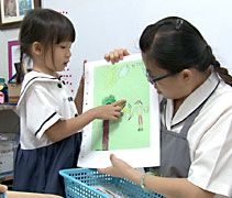 陳芊卉小朋友（左）向李靜薇老師（右）講解她所繪畫的內容。【攝影者：胡慧芬】