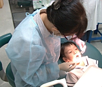 坐上診療椅，慈濟幼兒園的孩子們勇敢地張開嘴巴，讓牙醫吳秀金（左）檢查牙齒。【攝影者：胡慧芬】
