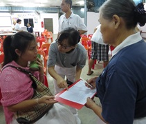 來自曼谷的妮娜（Nina，左一）在志工的協助下，報名參加浴佛典禮及萬人齋戒。【攝影：馬耀甄（慈甄）】