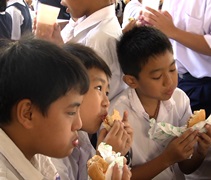 孩子們津津有味地吃著素漢堡包。【攝影者：蔡振加（惟立）】