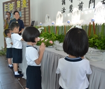 幼兒園小朋友走到浴佛臺前，禮佛足、接花香。 【攝影者：許證勝】