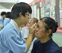 為促進親子之間的距離，新山慈濟人文學校安排慈少們發揮創意，在父母臉上彩繪愛的臉譜。李洪珠小心翼翼地在姑代母職的李觀娣臉上畫了顆愛心。【攝影者：陳志財（濟庭）】