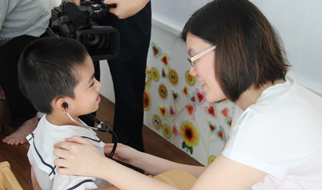 兒科醫師讓小朋友戴上聽筒，聆聽自己的心跳。【攝影者：黎力偉（濟循）】