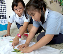 年紀比較小的孩子采用葉子，在白衣上構成圖案，來送給父親。【攝影者：胡慧芬】