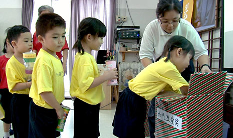 把心愛的獎杯，一一放進箱子裡，四間慈濟幼兒園的孩子首次進行互贈獎杯儀式。【攝影者：胡慧芬】