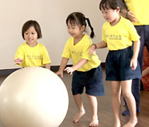 楊子芊小朋友（左二）扮演大姐姐的角色，在旁引導年紀較小的妹妹推動大龍球。【攝影者：胡慧芬】