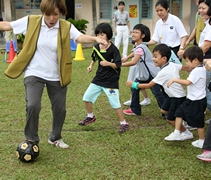 為了那顆球，廖佩詩（左一）等家長們都成了「大朋友」，跟著其他小朋友們一起追著球跑。【攝影者：徐可馨】