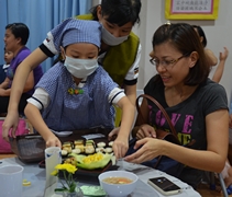 白薈恩小朋友小心翼翼地獻上日式料理，家長陳彥篥相當滿意她的服務。。【攝影者：李保輝】