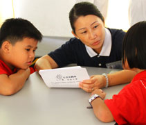 隊輔素琴媽媽很用心地和孩子們討論生活學習單的內容。【攝影者：何佩蓉】