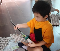 幼兒楊浚丞在紙皮塗上顏色。【攝影者：許證勝（濟韡）】